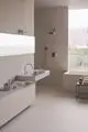 Badezimmeransicht mit einem modernen Waschtisch, integriertem Waschbecken und einer hohen Armatur in Chrom. Ideal Standard Produkte sind für ihre Funktionalität und Eleganz bekannt.